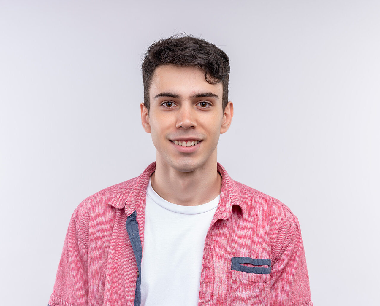 sonriente joven caucasico vistiendo camiseta rosa sobre fondo blanco aislado